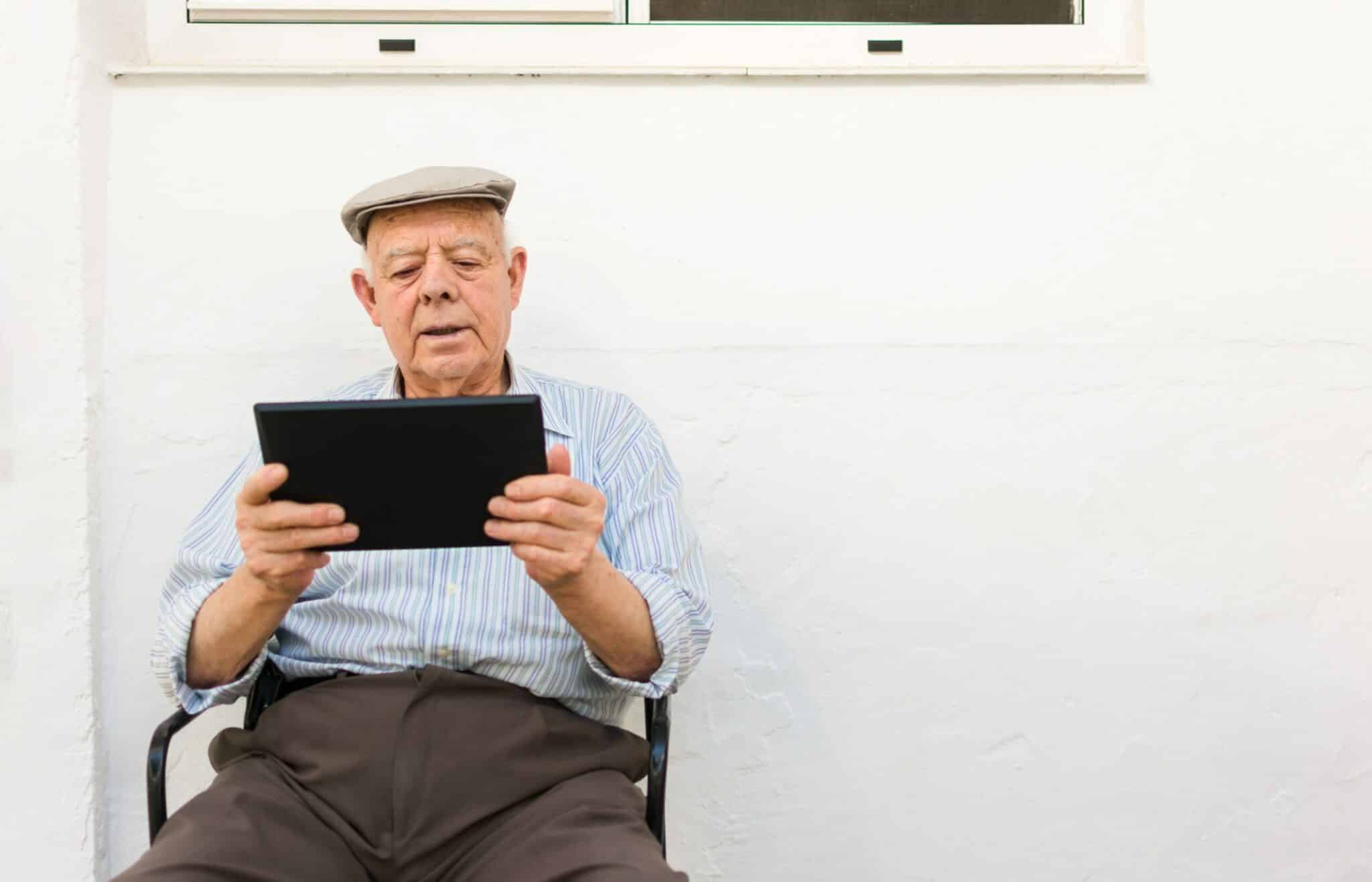 elderly man is using a tablet in the yard of his h 2022 05 09 23 11 56 utc scaled